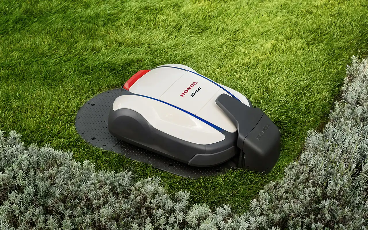 Installera Honda Miimo robotgräsklippares laddstation i en grön trädgård